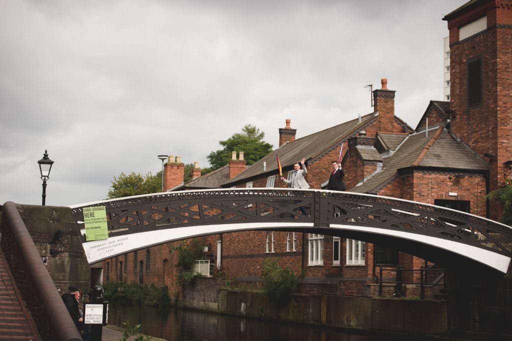 Cool wedding guests walking over a bridge on the canal in Birmingham