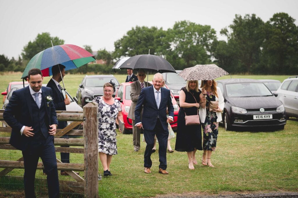 Barns & Yard Wedding Photography of guests arriving in the rain